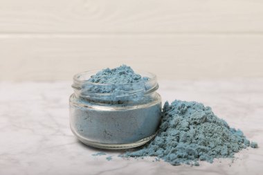 Blue Spirulina algae powder on white marble background. Diet and detox concept.Natural vegan superfood. Food supplement. Copy space. Place for text.