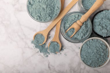 Blue Spirulina algae powder on white marble background. Diet and detox concept.Natural vegan superfood. Food supplement. Copy space. Place for text.