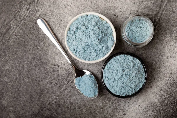 Blue Spirulina algae powder on black marble background. Diet and detox concept.Natural vegan superfood. Food supplement. Copy space. Place for text.