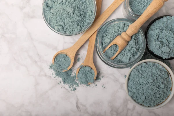 Blue Spirulina algae powder on white marble background. Diet and detox concept.Natural vegan superfood. Food supplement. Copy space. Place for text.