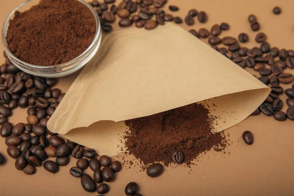 Coffee filter with ground powder on a brown background. fragrant coffee beans for an energizing and invigorating drink. Hand Drip Coffee, Flat Lay of Manual Brew Coffee Tools.
