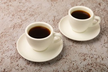 A cup of coffee on a white marble kitchen table. Hot invigorating aroma espresso drink. Place for text. Place to copy. Morning drink.