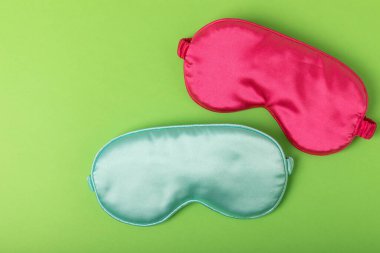 Sleeping mask on a green background. FLAT LAY. Concept of rest and quality of sleep. good night, insomnia, relaxation.