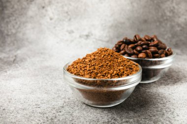Instant coffee and coffee beans on a black stone background. Aromatic coffee drink. Place for text. Space for copy text