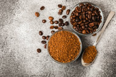 Instant coffee and coffee beans on a black stone background. Aromatic coffee drink. Place for text. Space for copy text