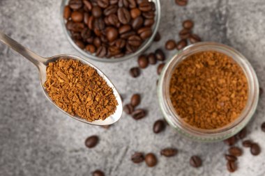 Instant coffee and coffee beans on a black stone background. Aromatic coffee drink. Place for text. Space for copy text