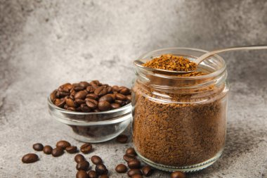 Instant coffee and coffee beans on a black stone background. Aromatic coffee drink. Place for text. Space for copy text