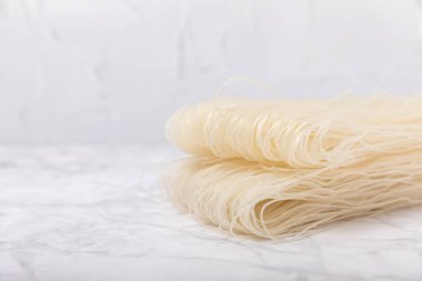 Rice noodles.Rice flour noodles on a white marble background.Close-up. Place for text. Copy space.