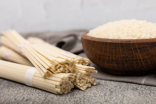 Rice noodles.Rice and noodles with rice flour in a wooden plate on a black background.Close-up. Place for text. Copy space.