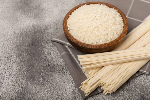 Rice noodles.Rice and noodles with rice flour in a wooden plate on a black background.Close-up. Place for text. Copy space.