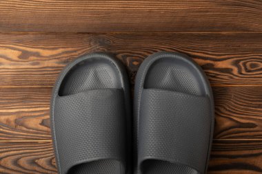 Rubber summer slippers. Replacement shoes for home or office. Yellow slippers on a background of brown space. Relax concepts. Space for text.Space for copy.
