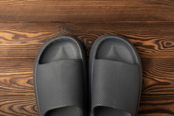 Rubber summer slippers. Replacement shoes for home or office. Yellow slippers on a background of brown space. Relax concepts. Space for text.Space for copy.