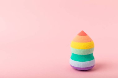 Colorful bright beauty sponges on a pink background. Beauty concept. Cosmetic tool for applying and blending and applying foundation, concealer. Copy space for text.