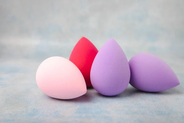 Beauty blender on a marble background. Beauty concept. Cosmetic tool for applying and blending and applying foundation, concealer. Copy space for text.