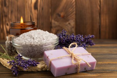 Lavender spa.Cosmetic products sea salt,body cream,handmade soap,scrub,essential oils and lavender flowers on brown wood.Natural herb cosmetic with lavender flowers. Beauty concept. copy space