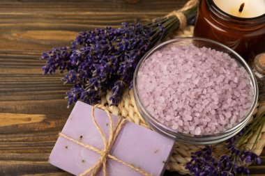 Lavender spa.Cosmetic products sea salt,body cream,handmade soap,scrub,essential oils and lavender flowers on brown wood.Natural herb cosmetic with lavender flowers. Beauty concept. copy space