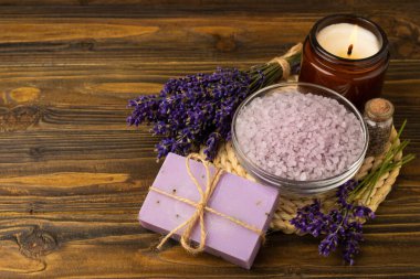 Lavender spa.Cosmetic products sea salt,body cream,handmade soap,scrub,essential oils and lavender flowers on brown wood.Natural herb cosmetic with lavender flowers. Beauty concept. copy space