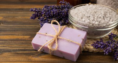 Lavender spa.Cosmetic products sea salt,body cream,handmade soap,scrub,essential oils and lavender flowers on brown wood.Natural herb cosmetic with lavender flowers. Beauty concept. copy space