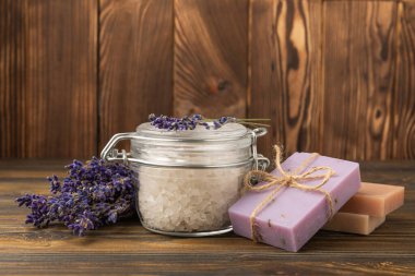 Lavender spa.Cosmetic products sea salt,body cream,handmade soap,scrub,essential oils and lavender flowers on brown wood.Natural herb cosmetic with lavender flowers. Beauty concept. copy space