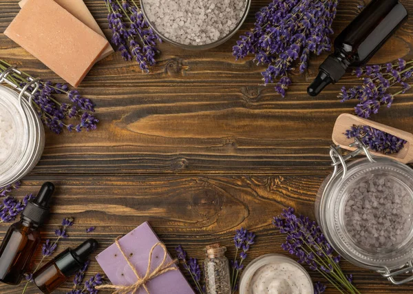 Lavender spa.Cosmetic products sea salt,body cream,handmade soap,scrub,essential oils and lavender flowers on brown wood.Natural herb cosmetic with lavender flowers. Beauty concept. copy space