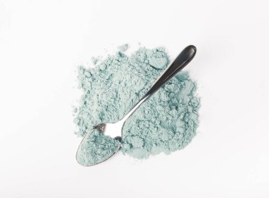 Blue spirulina powder in spoon isolated on white background. Natural vegan superfood. food supplement.