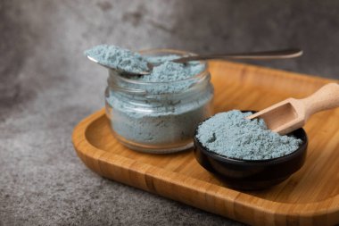 Blue spirulina powder in bowls and spoon on black marble background. Natural vegan superfood. food supplement. place for text. Copy space.