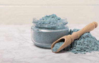 Blue spirulina powder in bowls and spoon on white marble background. Natural vegan superfood. food supplement. place for text. Copy space.