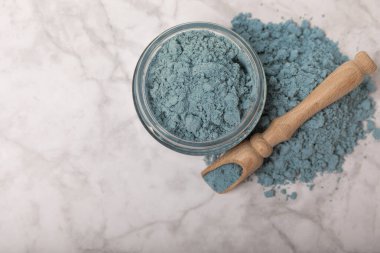 Blue spirulina powder in bowls and spoon on white marble background. Natural vegan superfood. food supplement. place for text. Copy space.