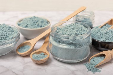 Blue spirulina powder in bowls and spoon on white marble background. Natural vegan superfood. food supplement. place for text. Copy space.