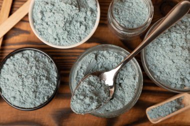 Blue spirulina powder in bowls and spoon on brown texture background. Natural vegan superfood. food supplement. place for text. Copy space.