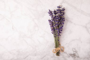 Bouquet of fragrant lavender on a white marble background. Top view. Place for text. Copy space.