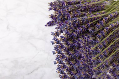 Bouquet of fragrant lavender on a white marble background. Top view. Place for text. Copy space.