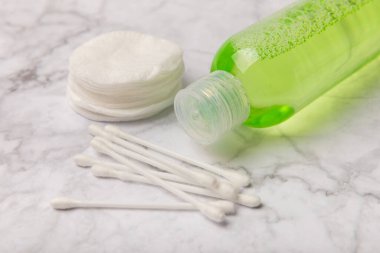 Micellar cleansing water and pads for removing makeup and cleansing the skin of sebium on a white marble table.Beauty concept. Flat lay.Copy the space text. Place to copy.