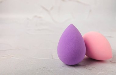 Beauty blender on light marble background. Cosmetics, makeup application tool. Beauty concept. Copy space. Place for text.