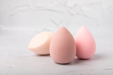 Beauty blender on light marble background. Cosmetics, makeup application tool. Beauty concept. Copy space. Place for text.