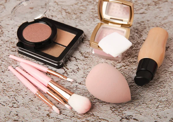 Makeup artist's tools on a brown marble dressing table. Beauty blender, sponge, brushes for powder, blush, concealer, foundation and eye shadow. Beauty concept. Place for text.Copy space.