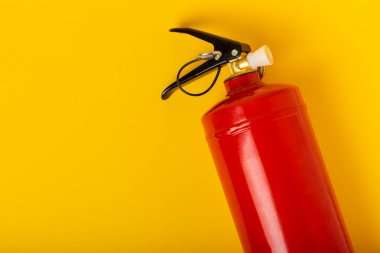 Fire extinguisher on yellow wall background. fire safety. Place for text. MOCAP