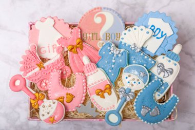 Set of baby shower cookies in a gift box on a marble background. Gender cookies.Baby shower party. Close-up. Flat lay. Place for text.
