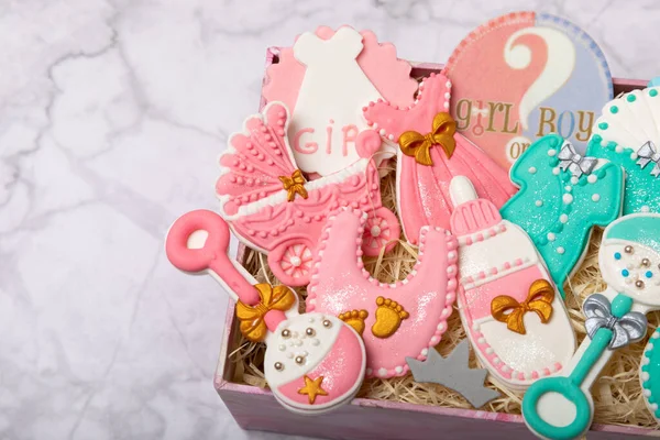 Set of baby shower cookies in a gift box on a marble background. Gender cookies.Baby shower party. Close-up. Flat lay. Place for text.