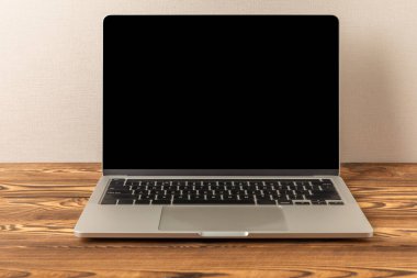 Laptop with a blank black screen on a white background. Laptop on the office table. MOCAP. Technology concept and design