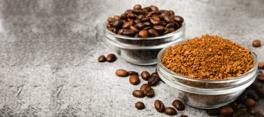 Coffee granules and coffee beans on a black textured background. Instant coffee drink. Energy hot drink. Place for text. Place for copy. Cheerful morning concept.