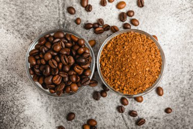 Coffee granules and coffee beans on a black textured background. Instant coffee drink. Energy hot drink. Place for text. Place for copy. Cheerful morning concept.