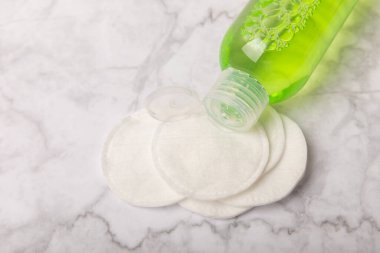 Micellar cleansing water and pads for removing cosmetics and cleansing the skin of sebium on a white marble background. Copy text. Place to copy. FLETLEY. Beauty concept.