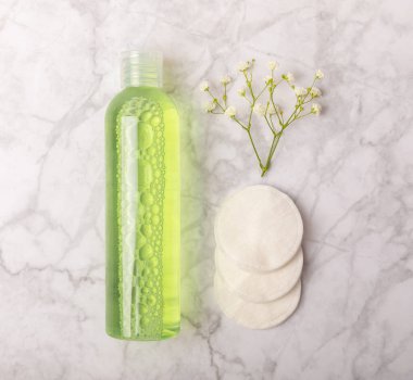Micellar cleansing water and pads for removing cosmetics and cleansing the skin of sebium on a white marble background. Copy text. Place to copy. FLETLEY. Beauty concept.