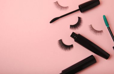 Composition with eyelash brush, eyelash curler, mascara and false eyelashes on pink background. Flat lay composition. Beauty industry concept.Place for text. Copy Spys.