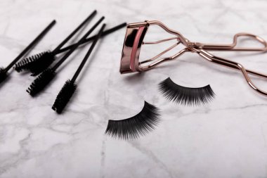 Composition with eyelash curler and false eyelashes on a colored background. Flat lay composition. Beauty industry concept.Place for text. Copy Spys.