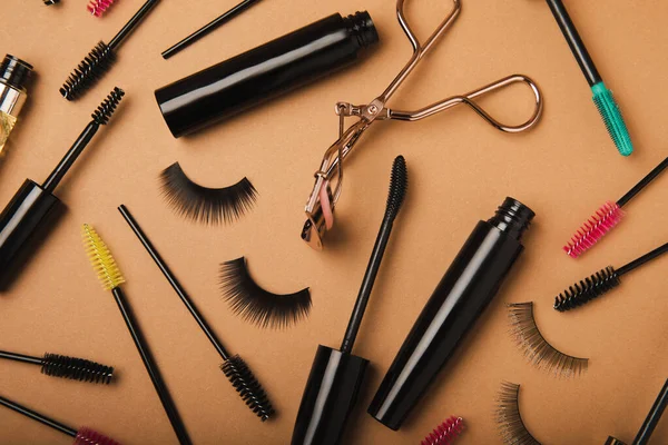 Composition with eyelash curler, mascara, eyelash growth oil and false eyelashes on colored background. Flat lay composition. Beauty industry concept.Place for text. Copy Spys.