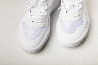 Pair of white shoes on a white texture background. Sport shoes. Unisex. Street style.