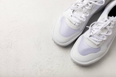 Pair of white shoes on a white texture background. Sport shoes. Unisex. Street style.