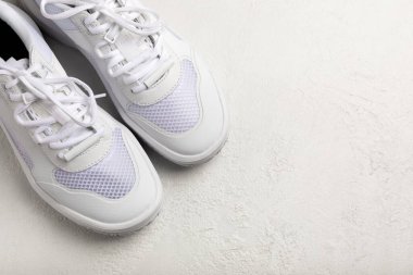 Pair of white shoes on a white texture background. Sport shoes. Unisex. Street style.